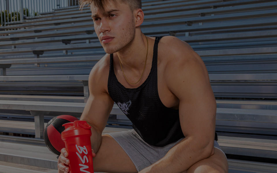 man holding bsn shaker while sitting on steps