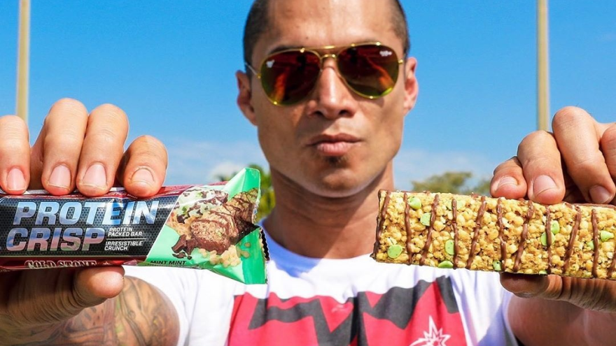 man holding two protein crisp bars